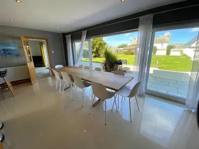 a dining room with a table and chairs and a large window at Boskilly in St Merryn