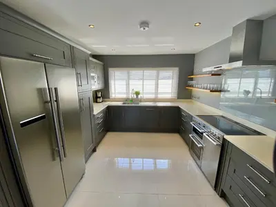 a kitchen with gray cabinets and stainless steel appliances at Boskilly in St Merryn
