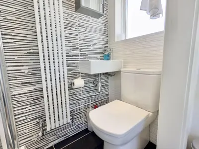 a bathroom with a white toilet and a sink at Hardown in St Merryn
