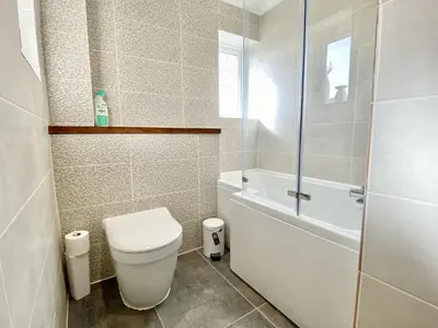 a bathroom with a toilet and a tub and a shower at Morwennol in St Merryn
