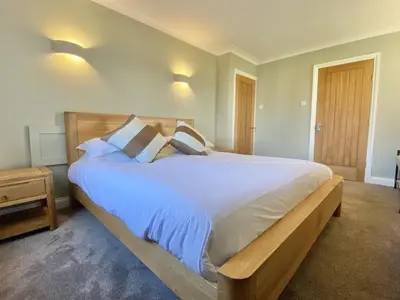 a bedroom with a large bed with white sheets and pillows at Morwennol in St Merryn