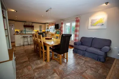 a kitchen and living room with a table and a couch at Polcarrek in St Merryn