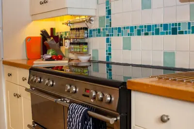 a kitchen with a stove and a counter top at Polcarrek in St Merryn