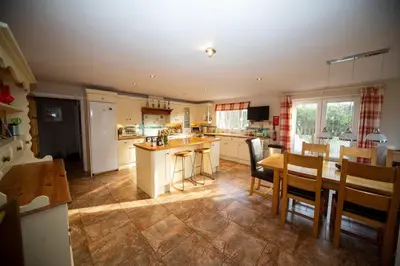 a kitchen and dining room with a table and chairs at Polcarrek in St Merryn