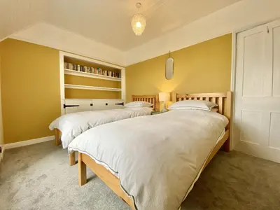 two beds in a room with yellow walls at Treaaron in St Merryn