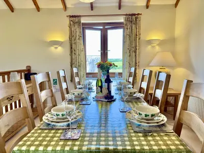 a dining room with a long table and chairs at Wharf Cottage in Padstow