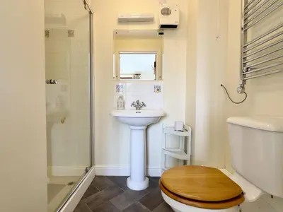 a bathroom with a toilet and a sink and a shower at Wharf Cottage in Padstow