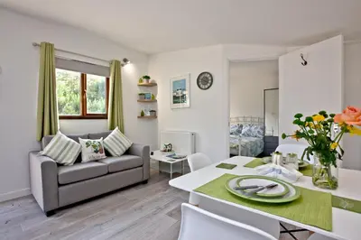 a living room with a couch and a table at The Cabin at Hillhead farm in Saint Columb Major