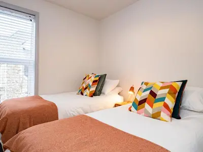 a bedroom with two beds and a window at The Lookout in Wadebridge