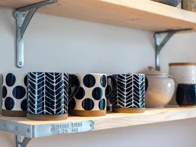 a row of coffee mugs on a shelf at The Lookout in Wadebridge