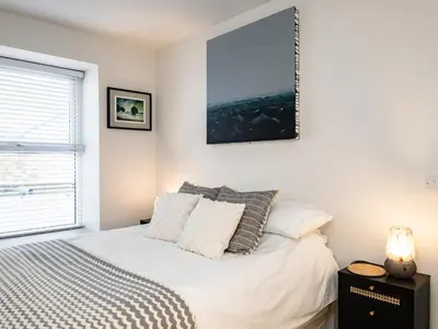 a bedroom with a bed and a picture on the wall at The Lookout in Wadebridge