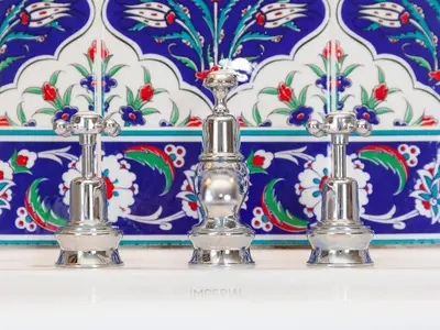 three silver candlesticks on a shelf in front of a wall at St Ives View in St Ives