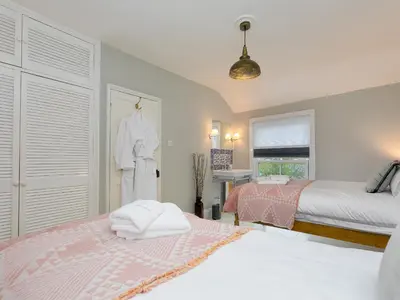 a bedroom with two beds and a robe hanging on a door at St Ives View in St Ives