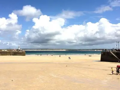 a beach with a bunch of people in the water at Grey Mullet Guest House in St Ives