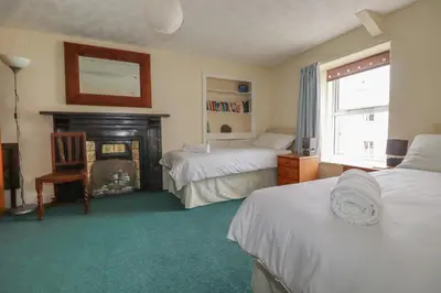 a bedroom with two beds and a fireplace at Narnia in Delabole
