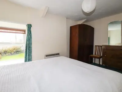 a bedroom with a white bed and a window at Narnia in Delabole