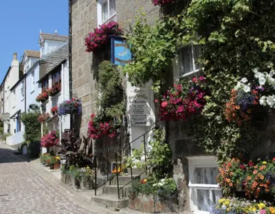 a street with flowers on the side of a building at Grey Mullet Guest House in St Ives