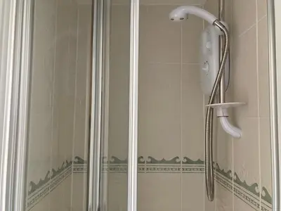 a shower with a shower head in a bathroom at Grey Mullet Guest House in St Ives