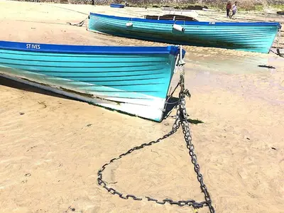two boats tied up on a beach with a chain at Grey Mullet Guest House in St Ives