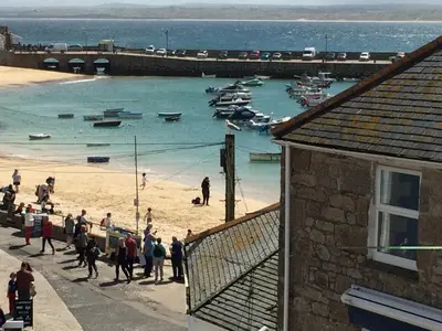 a group of people on a beach with boats in the water at Grey Mullet Guest House in St Ives