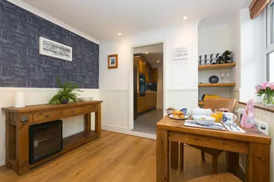 a living room with a table and a fireplace at Oystercatcher House in St Ives