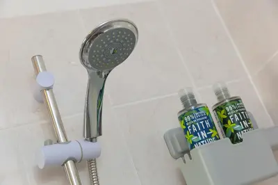 a shower head and a blow dryer in a bathroom at Oystercatcher House in St Ives