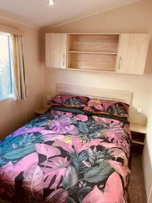 a bedroom with a bed with a colorful comforter at 69 Newquay bay resort Pet friendly in Newquay