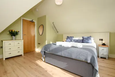 a bedroom with a large bed with blue pillows at Fishermans Heights in Polperro