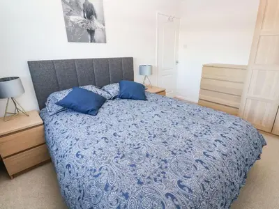 a bedroom with a blue bed with two blue pillows at Dunes View in Newquay
