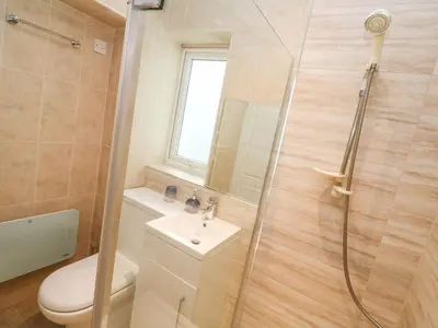 a bathroom with a shower and a toilet and a sink at Dunes View in Newquay