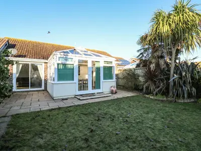 a house with a greenhouse in a yard at Dunes View in Newquay