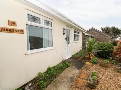 a house with a sign that reads dums view at Dunes View in Newquay