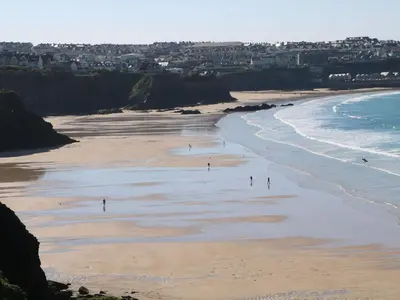 people walking on the beach near the ocean at Dunes View in Newquay