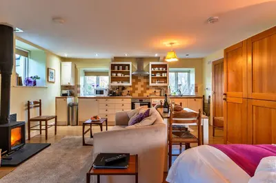 a living room with a couch and a fire place at Finest Retreats - Jenny Wren in Boscastle