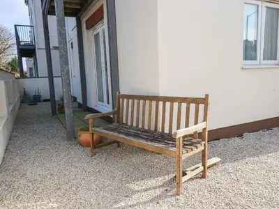 a wooden bench sitting outside of a building at Flat 4 in Newquay