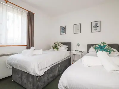 two beds in a room with a window at Flat 4 in Newquay