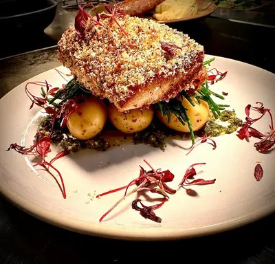 a white plate with a sandwich and potatoes on it at The White House at The Tinners Arms in St Ives