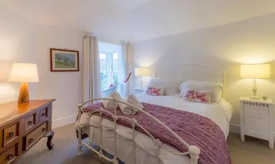 a bedroom with a large bed and a window at The White House at The Tinners Arms in St Ives