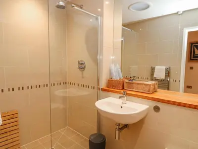 a bathroom with a sink and a glass shower at A Stone's Throw in Torpoint