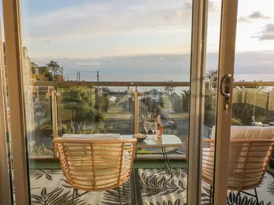 a balcony with a table and chairs on a patio at A Stone's Throw in Torpoint