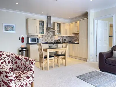 a kitchen and living room with a table and a couch at Penryn in St Ives
