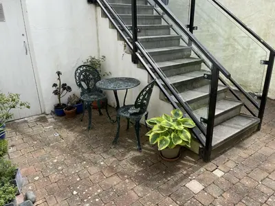 a patio with a table and chairs and stairs at Penryn in St Ives