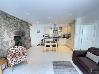 a living room with a couch and a stone fireplace at Penryn in St Ives