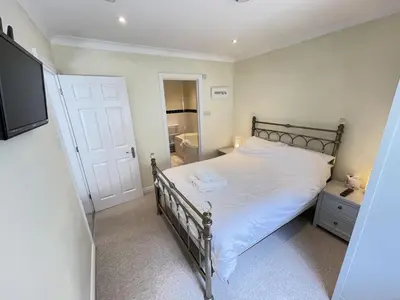 a bedroom with a bed and a flat screen tv at Penryn in St Ives