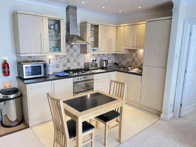 a kitchen with a table with chairs and a microwave at Penryn in St Ives