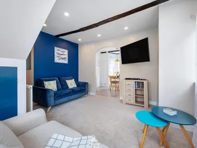 a living room with a couch and a tv at Holiday Home Cherry Orchard Cottage by Interhome in Mevagissey