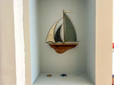a shelf with three toy sailboats on a wall at Holiday Home Cherry Orchard Cottage by Interhome in Mevagissey