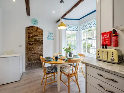 a kitchen with a table and chairs in a kitchen at Holiday Home Cherry Orchard Cottage by Interhome in Mevagissey