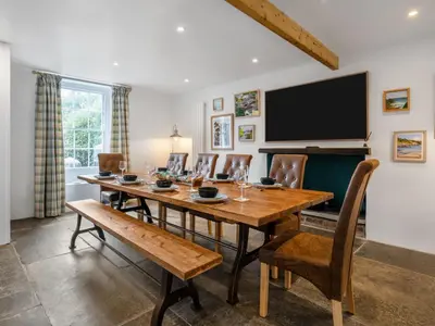 a dining room with a table and chairs and a television at Holiday Home Cherry Orchard House by Interhome in Mevagissey
