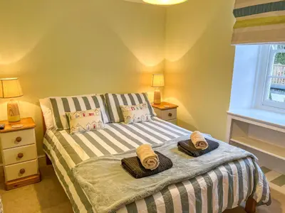 a bedroom with a bed with two towels on it at Holiday Home Cherry Orchard House by Interhome in Mevagissey